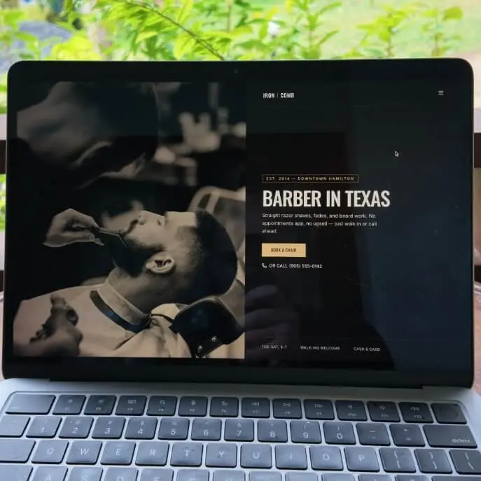 Published barber website open on a laptop with the shop photo and Book a chair button